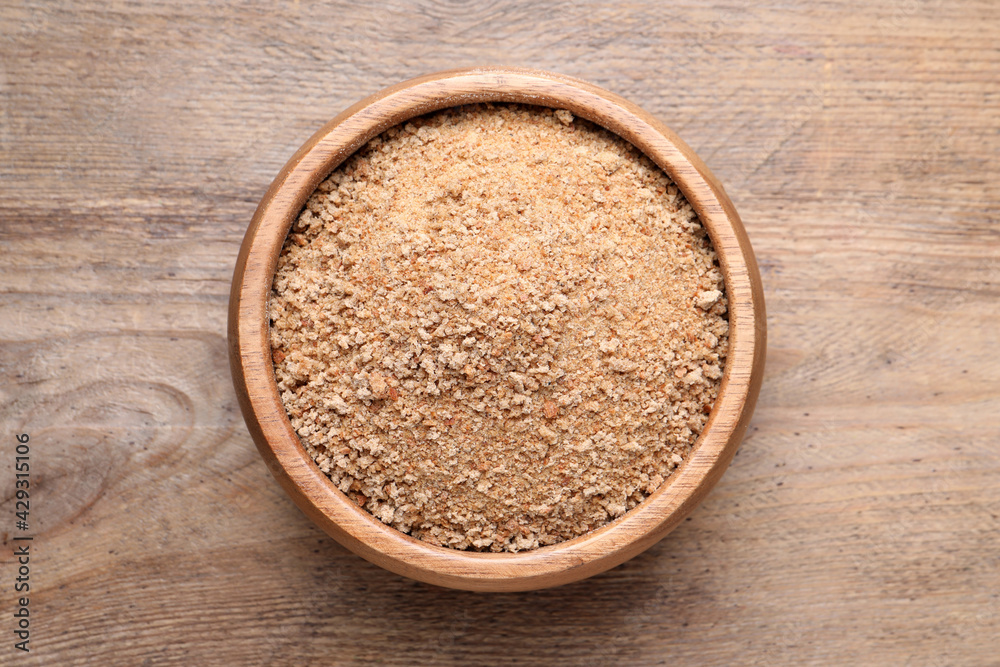 Fresh breadcrumbs in bowl on wooden table, top view Fresh breadcrumbs in bowl on wooden table, top view