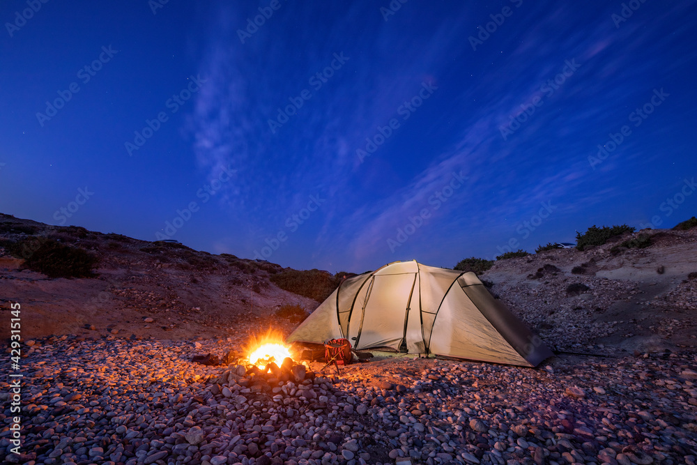 campers tent in the night with mountains and dark blue sky 
