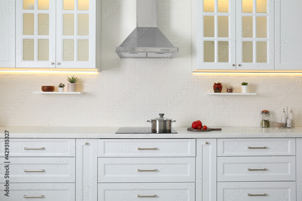 Fototapeta premium Elegant kitchen interior with modern stove and stylish furniture