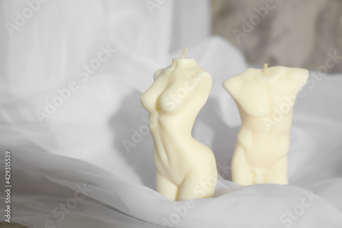 Beautiful male and female body shaped candles on fabric