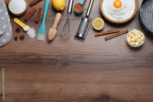 Cooking utensils and ingredients on wooden table, flat lay. Space for text