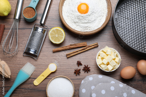 Cooking utensils and ingredients on wooden table, flat lay