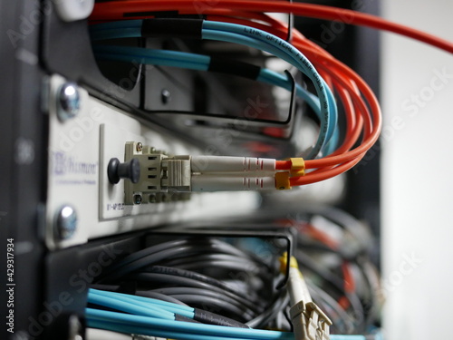 fiber optic cable network connected to internet switch servers in data center.
