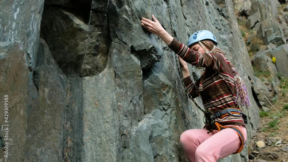 Woman climber passes challenging tracks on the rock