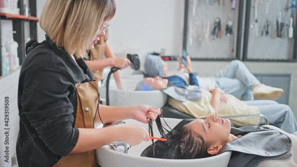 Asian young girl getting hair treatment by professional hairdresser. Asian young girl getting hair treatment by professional hairdresser.