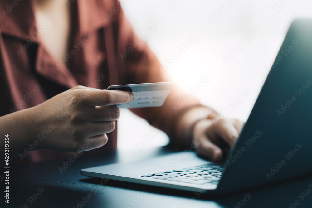 Hands holding plastic credit card and using laptop. Online shopping concept. Hands holding plastic credit card and using laptop. Online shopping concept.