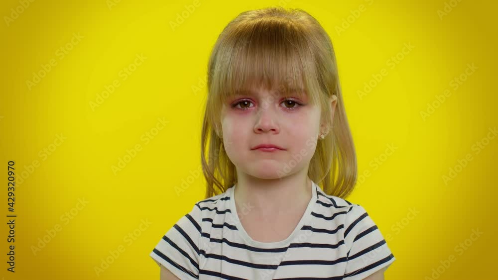 Disappointed upset little blonde teen kid child girl with tears on eyes cries from despair, being sad because of unfair things. Isolated on yellow studio background. Young children lifestyle emotions Disappointed upset little blonde teen kid child girl with tears on eyes cries from despair, being sad because of unfair things. Isolated on yellow studio background. Young children lifestyle emotions