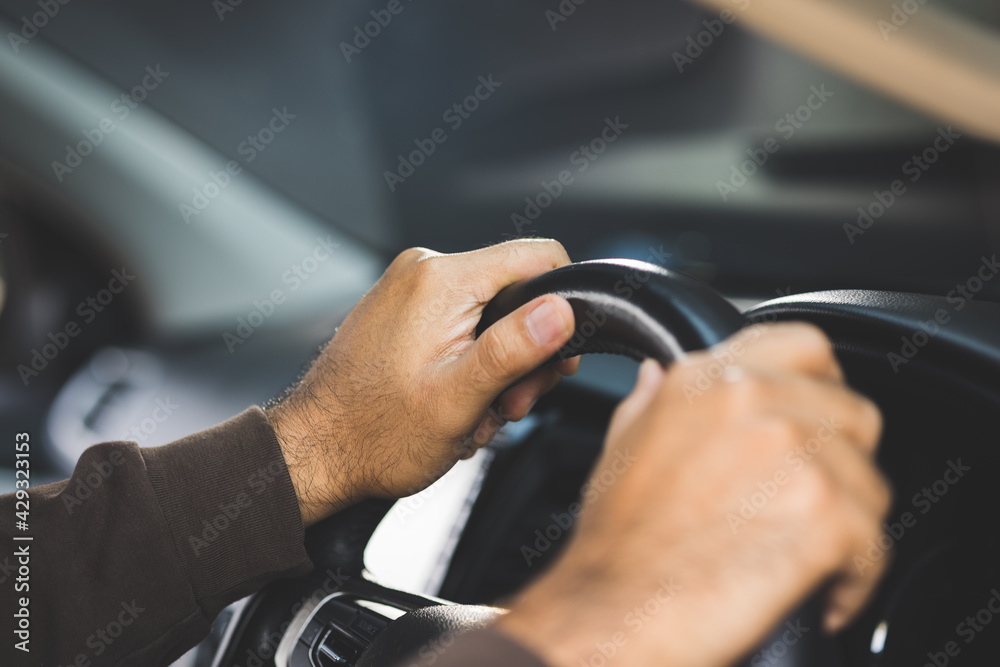 The hand is holding the steering wheel of the car Safe driving The hand is holding the steering wheel of the car Safe driving