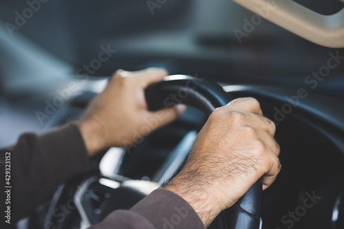 The hand is holding the steering wheel of the car Safe driving