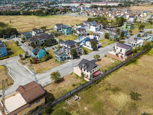 Aerial of a typical township or gated village developed from former farmland in the Philippines. Many lots are still empty or undeveloped. In Bacoor, Cavite. photo