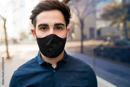 Portrait of young man wearing face mask outdoors.