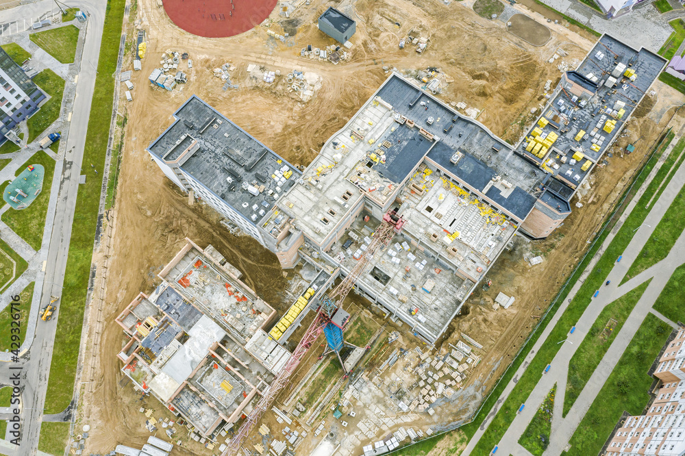 new school building in residential area under construction. roof construction in progress. aerial view