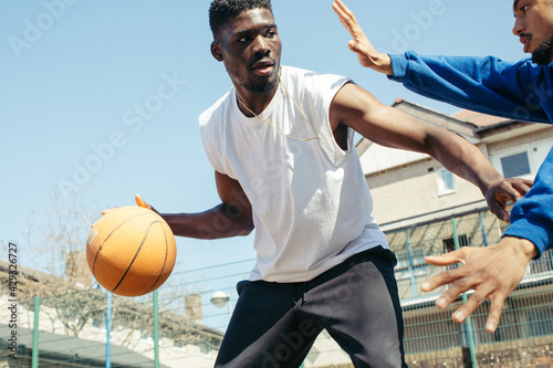 Fototapeta Naklejka Na Ścianę i Meble -  Two friends playing basketball 