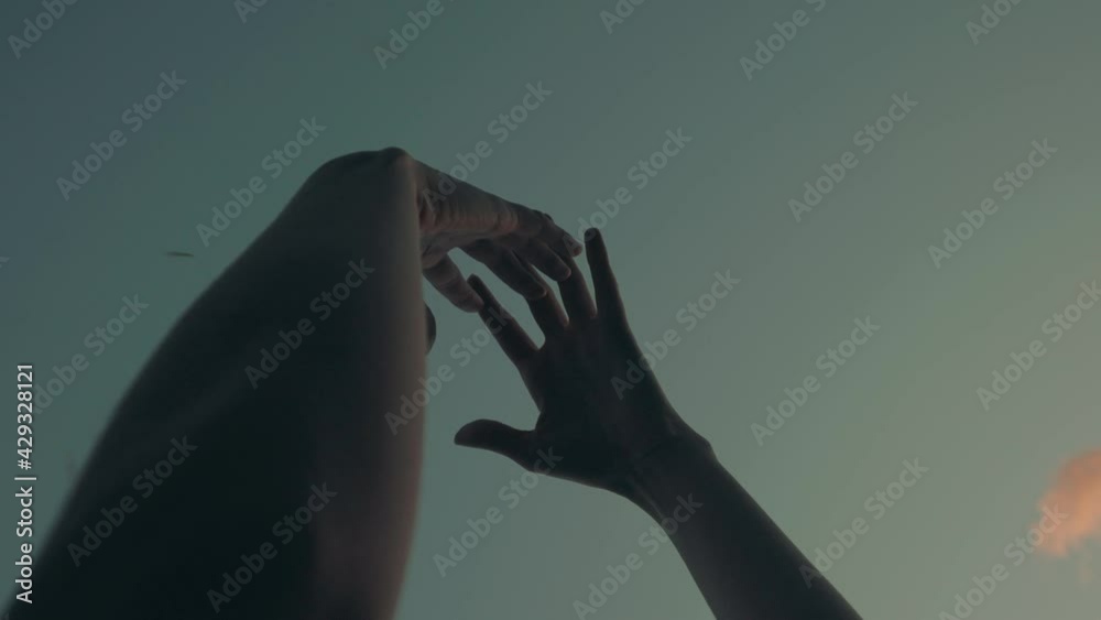 Arms raised to sky with hands slowly moving for ritual and leaves falling. Low angle Slow-motion