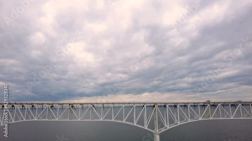 Slow motion aerial footage of Westbound traffic on Route 50 crossing over Chesapeake Bay Bridge. Cars and trucks are passing over the sea on bridge photo