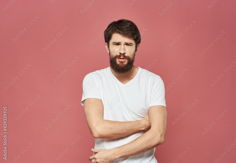 Man on a pink background in a white t-shirt emotions model cropped view Man on a pink background in a white t-shirt emotions model cropped view