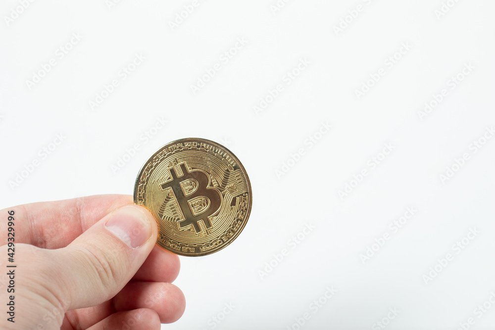Hand holding a golden bitcoin isolated on white background. Hand holding a golden bitcoin isolated on white background.