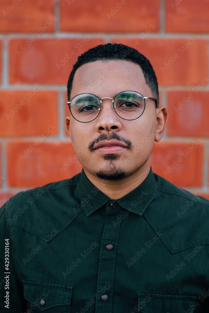 portrait of male model with green military t-shirt on brick wall