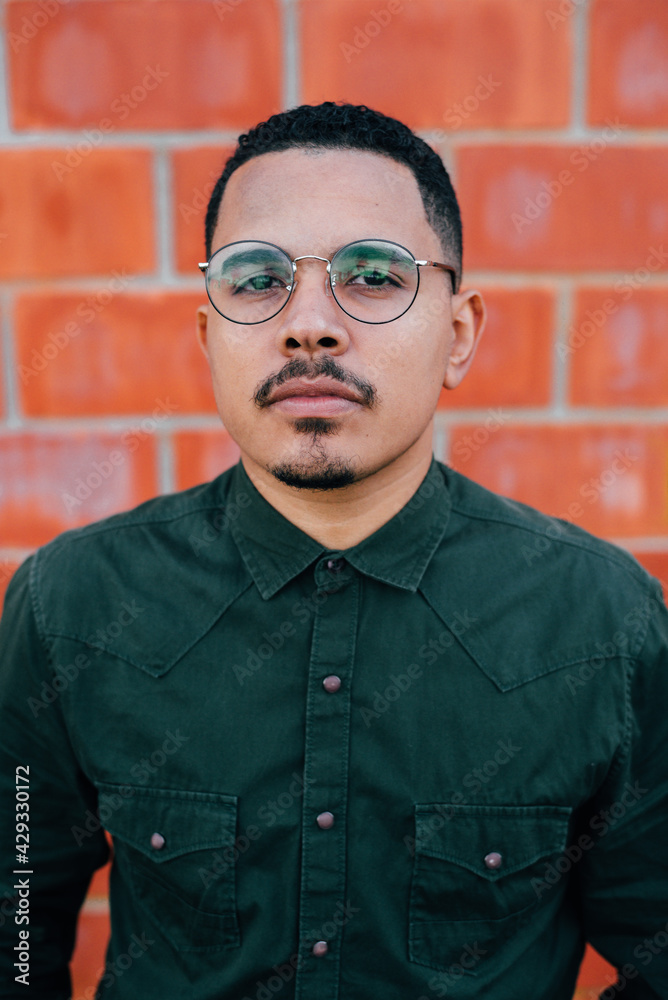 portrait of male model with green military t-shirt on brick wall portrait of male model with green military t-shirt on brick wall