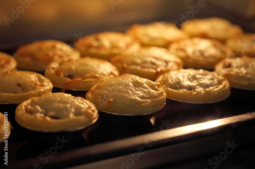 Mini pie from meat and mushrooms baking in industrial oven