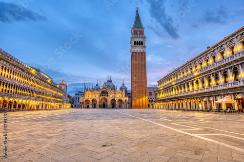 An empty St Marks square in Venice with the bell tower and the cathedral at dawn photo