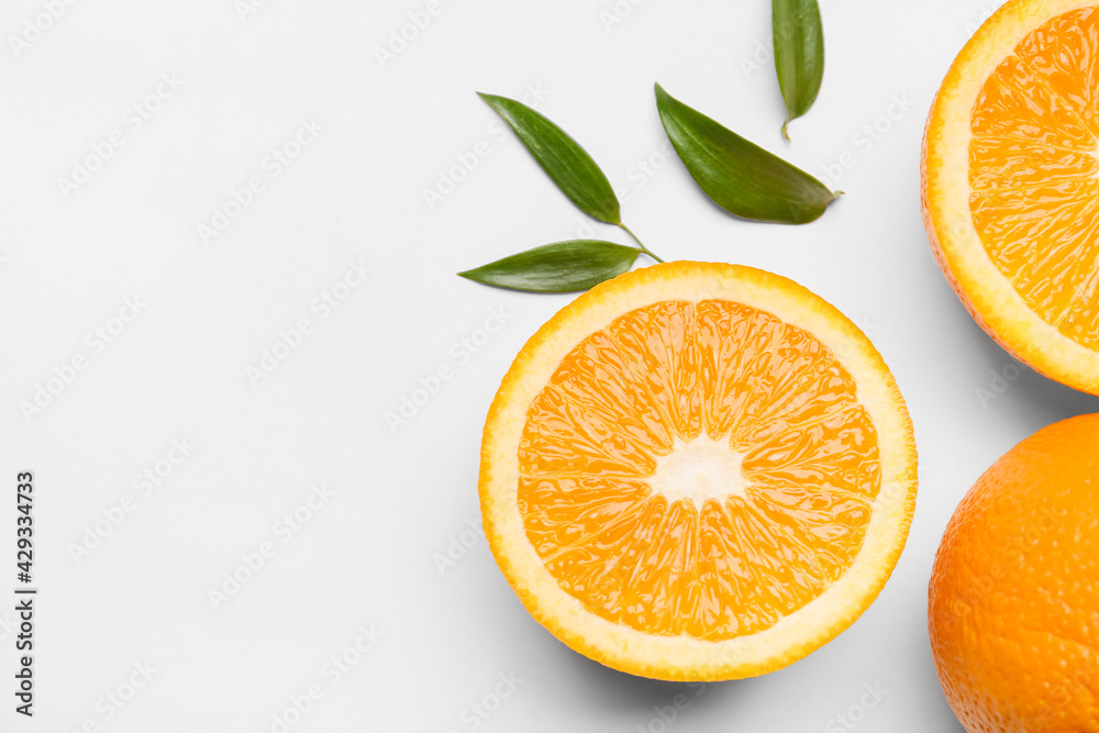 Fototapeta premium Fresh oranges with green leaves on white background