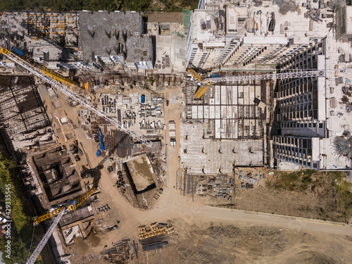 Aerial of a construction site, midrise residential condominiums constructed with prefab concrete. Several tower cranes erected onsite. photo