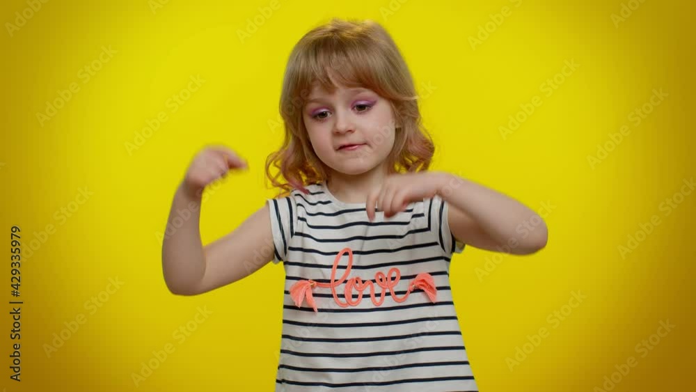 Look at advertisement. Kid child pointing down, saying to subscribe, gesturing ok and like, showing place for commercial, promotional information below. Yellow background. Teen children girl blogger Look at advertisement. Kid child pointing down, saying to subscribe, gesturing ok and like, showing place for commercial, promotional information below. Yellow background. Teen children girl blogger