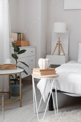 Bedside table with books and decor in interior of room