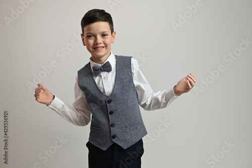 Portrait of a young guy with a smile in a suit with a bow tie on a white background