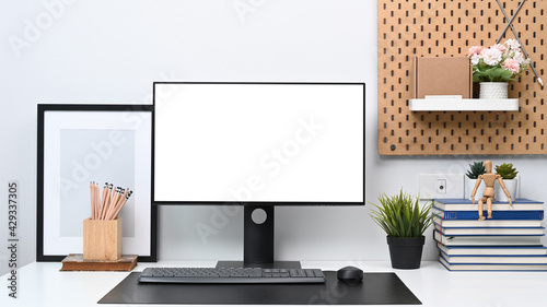 Cuadro en lienzo Front view of computer with blank screen and office supplies on white table at modern home office