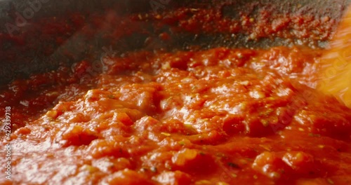 Hot tomato sauce is boiling and stirring in a pan for pizza or pasta, 4k footage