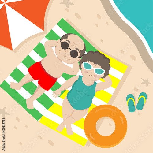 Elderly couple sunbathing on the beach.