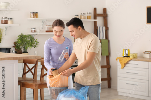 Young couple putting garbag...