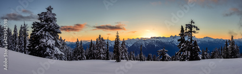 Panoramic View of Canadian Nature Landscape on top of snow covered mountain and trees during colorful spring sunset. Taken on a hike up Elfin Lake in Squamish, North of Vancouver, BC, Canada.