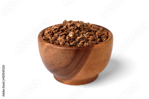 Chocolate granola in wooden bowl isolated on white background. © Natallia