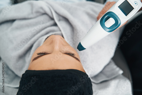 Beauty salon customer getting a non-invasive anti-aging facial treatment