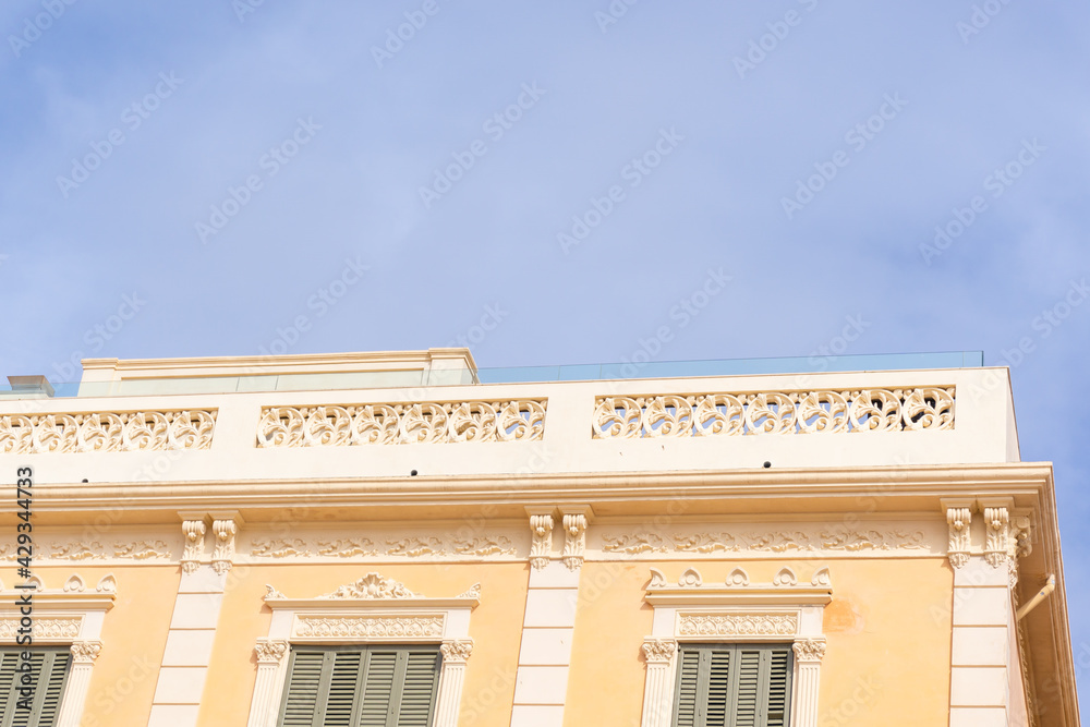 Image of the cornice of a pastel yellow building