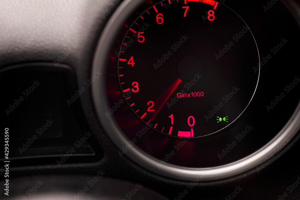 Car dashboard tachometer rev counter with red background lighting and needle Car dashboard tachometer rev counter with red background lighting and needle