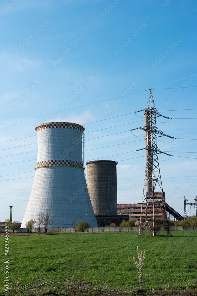 Disaffected coal-fired power plant station in the field clear day blue sky steaming furnace