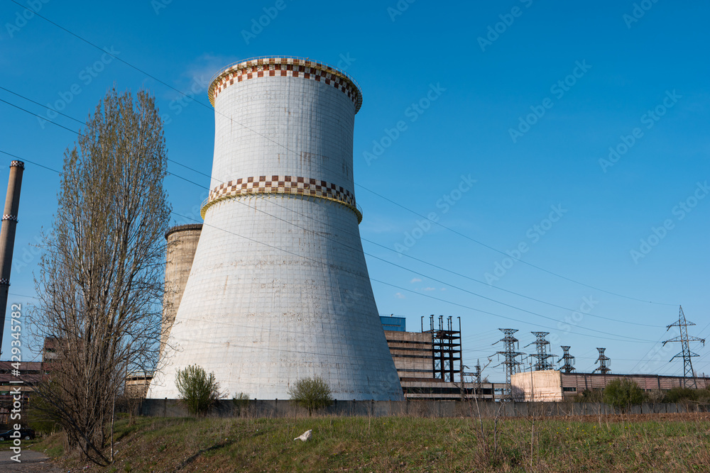 Disaffected coal-fired power plant station in the field clear day blue sky steaming furnace