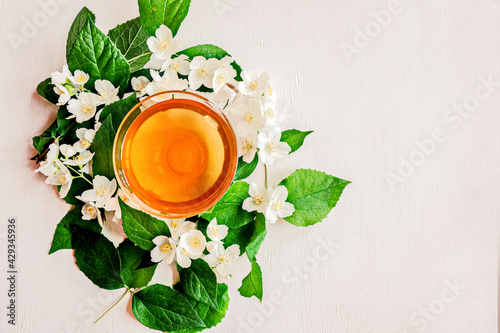 Glass Cup of green Jasmine fragrant, medicinal tea. Alternative medicine. White wooden background. The view from the top. Copy space.