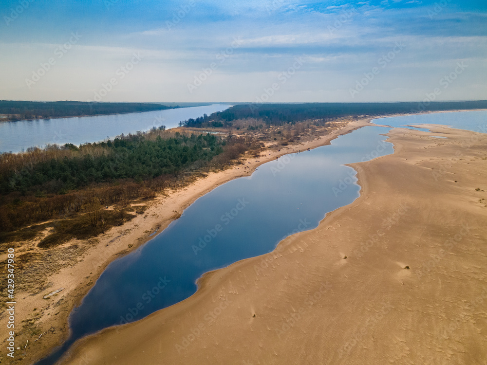 Rezerwat Mewia Łacha, widok na wpadającą rzekę Wisłę do zatoki oraz ujście Wisły, czysta tafla woda i żółty piasek na brzegu