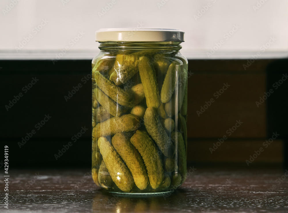 Little jar full of small cornichons. Glass jar with marinated cucumbers Little jar full of small cornichons. Glass jar with marinated cucumbers