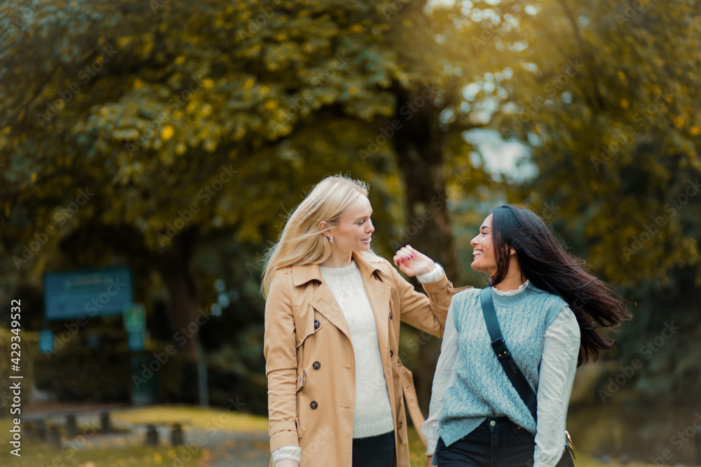 Fototapeta premium Two women walking trough park and talking.