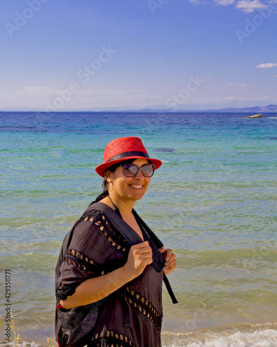 portrait of beautiful young woman in a red hat on the beach 