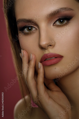 Portrait of a girl with gentle makeup on a red background