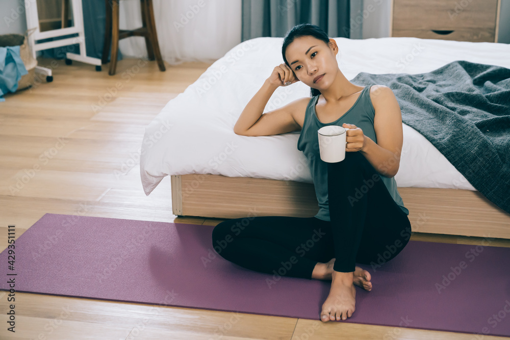 asian yoga instructor thinking about how to make a living while sports