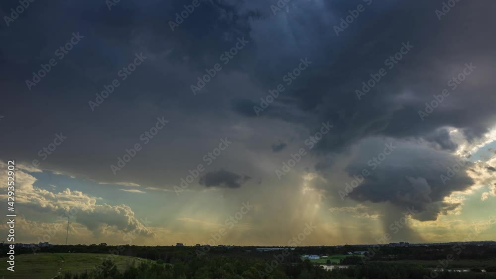 Storm cloud unfolding over western Sydney and Parramatta city. Sunset view from the hill, rain clouds passing with sun rays.