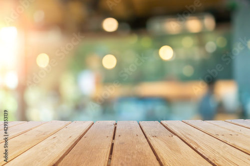 Selective focus of wooden table with blur coffee and restutant cafe with customers. © ant
